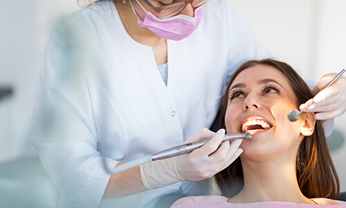 Dentist giving female patient a dental exam