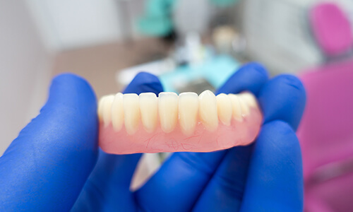 Dentist holding bottom dentures in hand