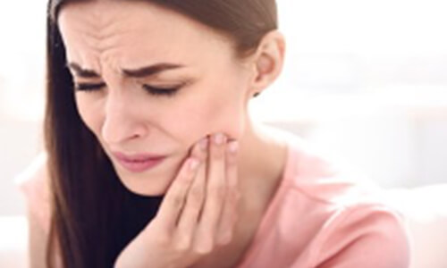 Woman holding jaw with severe toothache