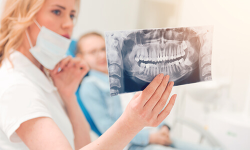 Dentist and patient examining x-ray
